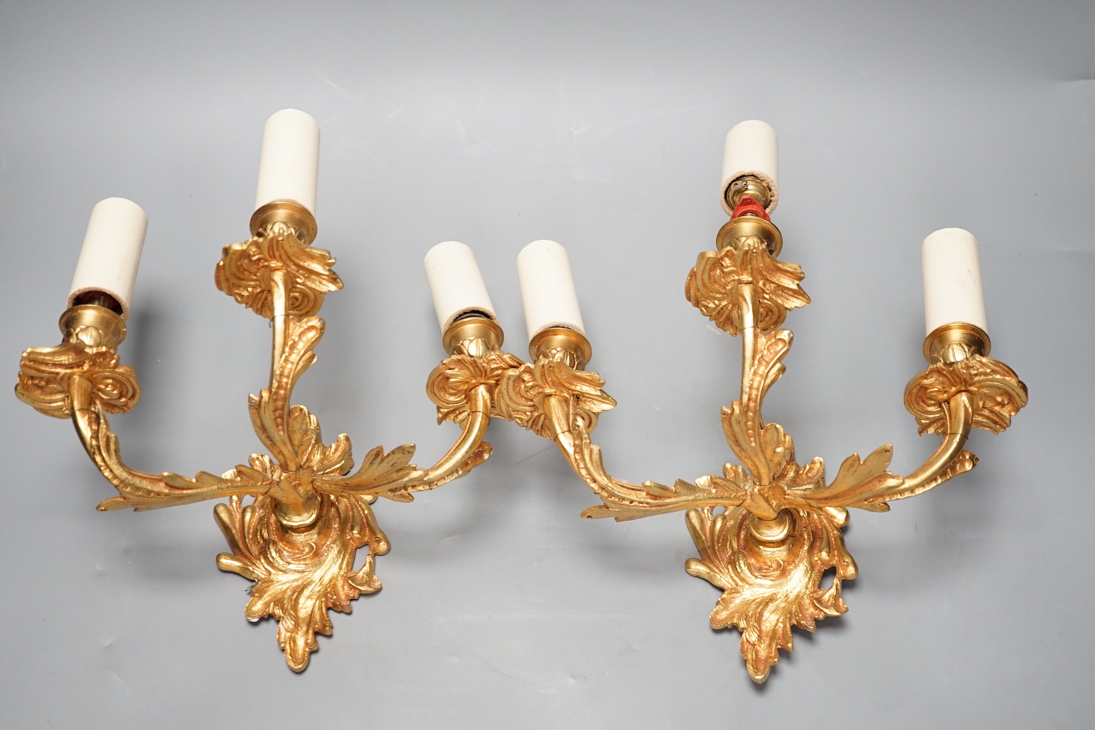 A pair of ormolu three branch wall lights